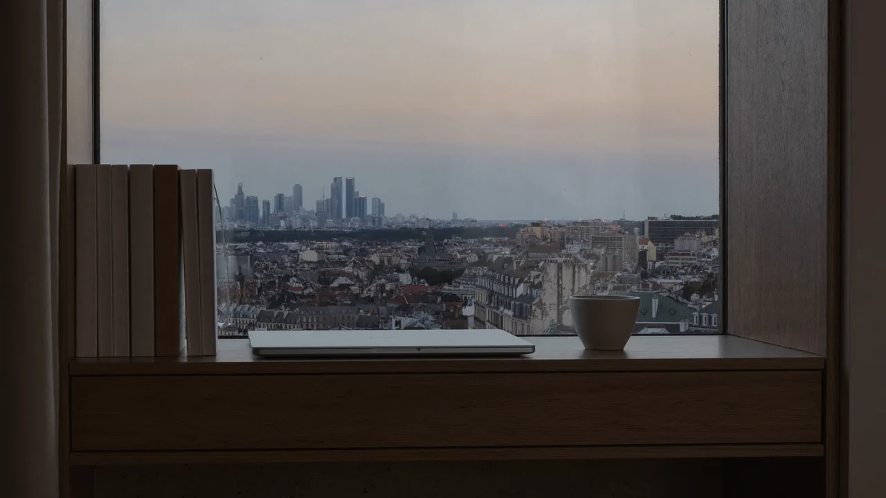 Lernnische am Fenster mit Notizbüchern und Blick auf Zürcher Dächer im Abendlicht